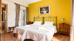 Ein Doppelbett mit gesteppter Bettdecke, zwei Nachttische, ein Beistelltisch und ein Bild an der Wand.