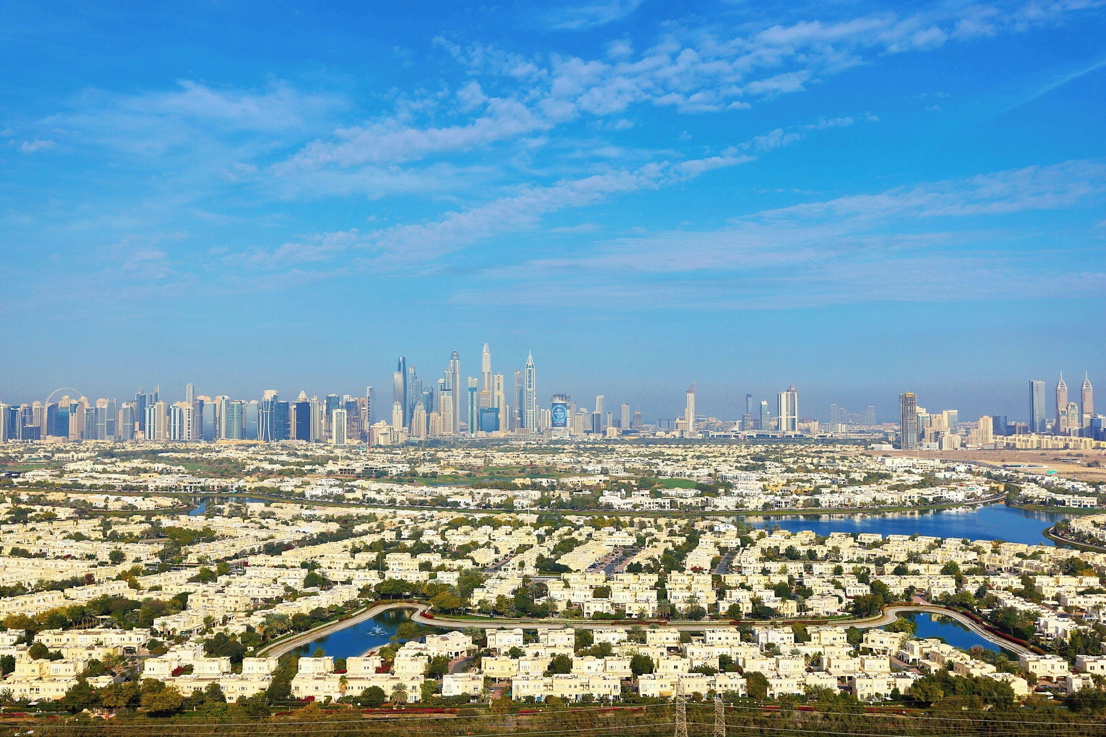 A cityscape with a dense residential area and a skyline of high-rise buildings.
