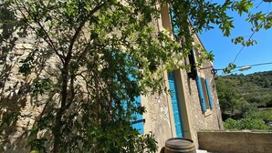 A stone building with blue shutters, a bench, and a barrel. - Beautifully restored wine grower’s house with pool in stunning riverside village (Roquebrun)