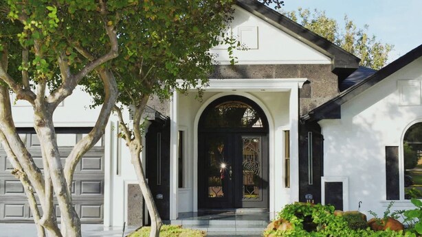 A house with a white exterior, a black front door, and a covered porch. - Luxury home with Pool, Electric Vehicle charger in McAllen near by hospitals and (McAllen)