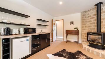 Een moderne keuken met inbouwapparatuur, een eethoek met een tafel en stoelen, en een open haard.