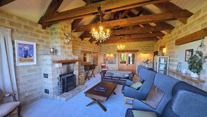A cozy living room with a stone fireplace, wooden beams, and a chandelier. - 1BR Retreat Self-Contained & Private  - Waitaki (Lake Tekapo)