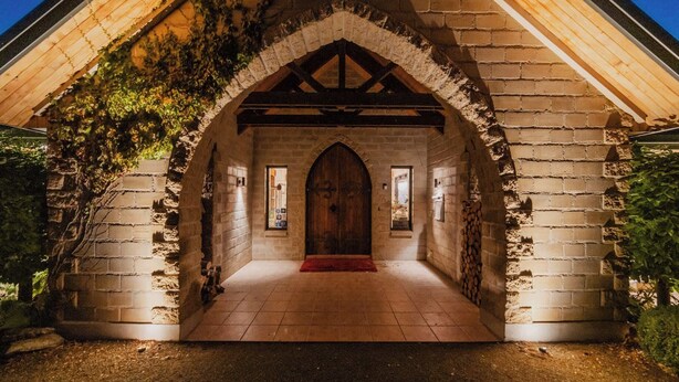 A stone building with a wooden door, a red carpet, and a brick wall. - 1BR Retreat Self-Contained & Private  - Waitaki (Lake Tekapo)