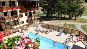 A pool area with multiple levels of balconies, a pool, and surrounding greenery. - Ski-in/ski-out & foot of the slopes, swimming pool, balcony, tv, ski locker, 50m², La Norma (La Norma)