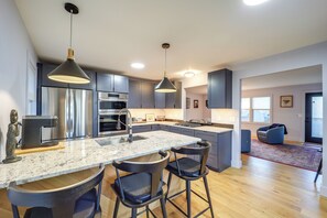 A modern kitchen with granite countertops, stainless steel appliances, and dark cabinetry. - Steps to Dtwn & Fabulous Restaurants: Chic Condo (Blowing Rock)