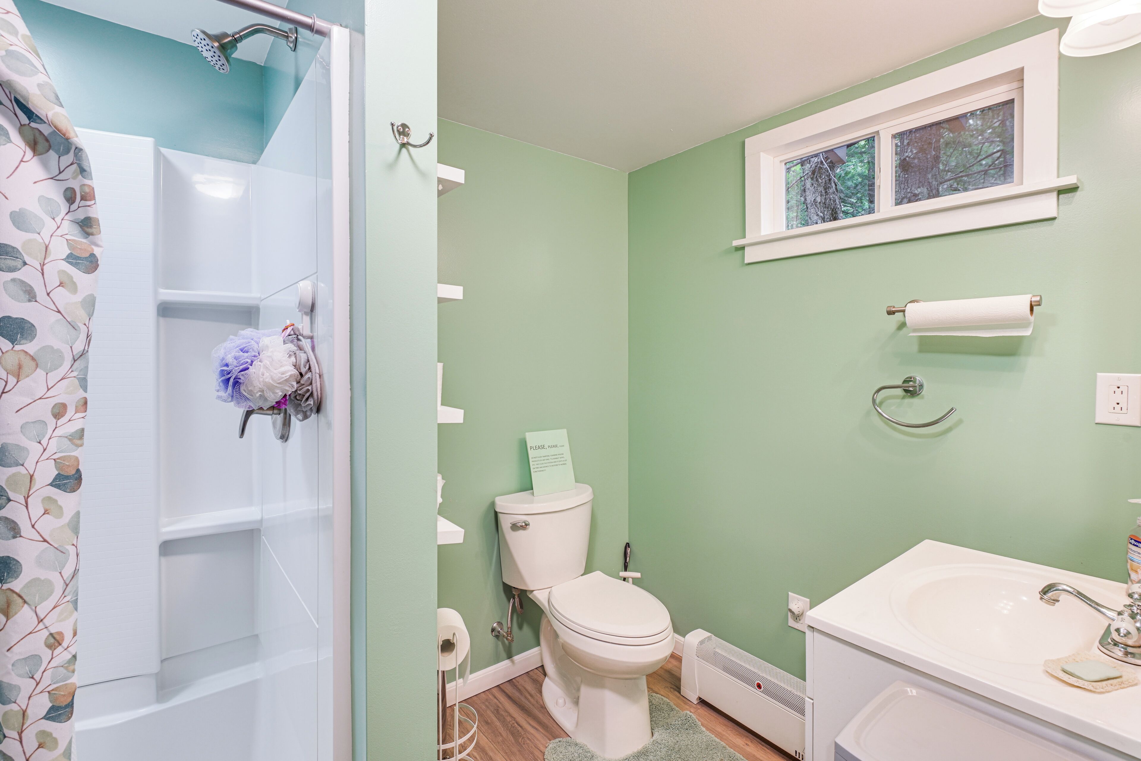 Een badkamer met toilet, wastafel en douche.