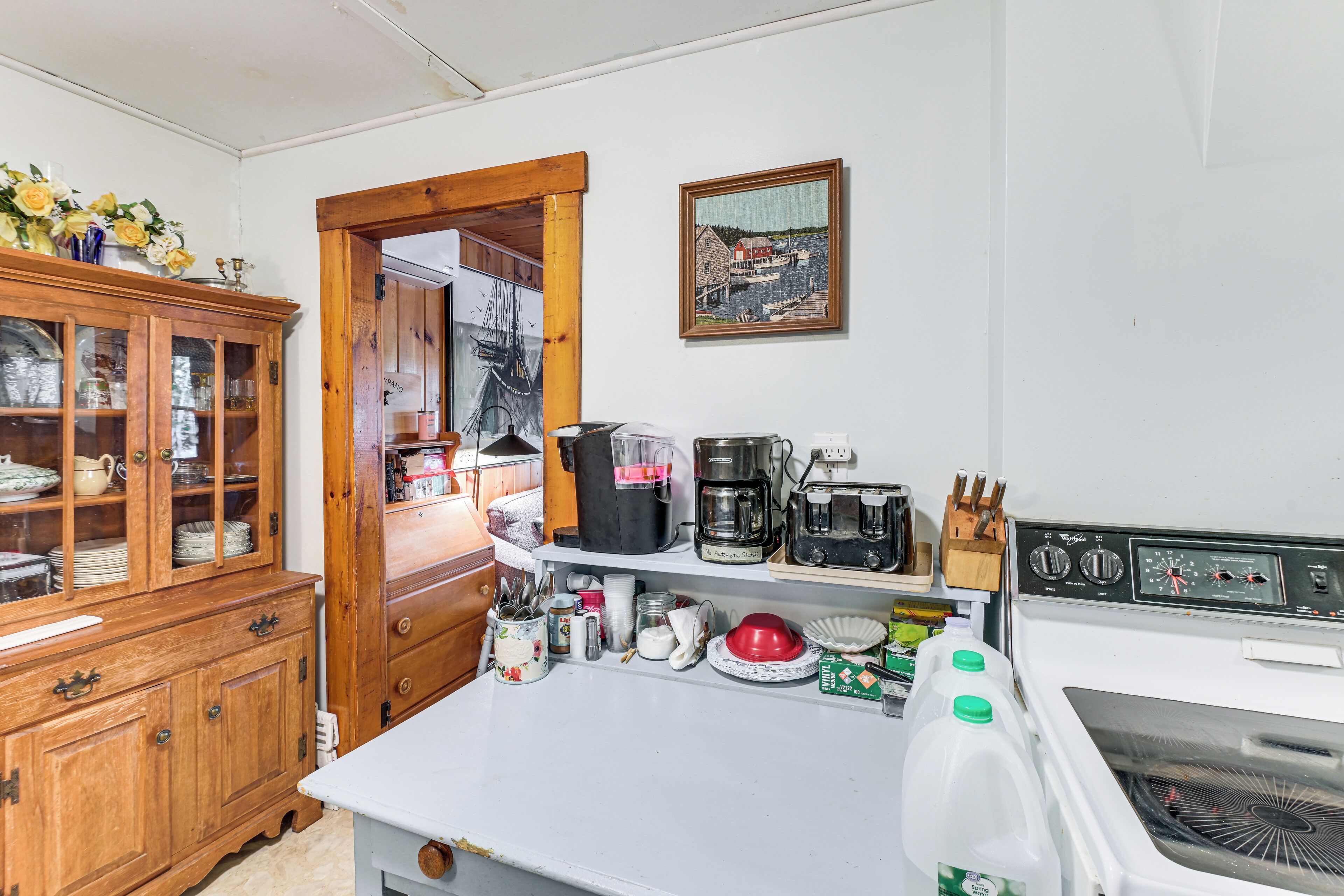 A kitchen with wooden cabinets, a coffee maker, a microwave, and a refrigerator.