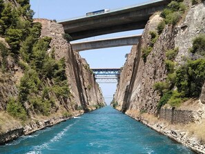 A bridge over a narrow waterway flanked by rocky cliffs. - Loutraki Getaway - Cozy and Quiet Nest (Loutraki-Agioi Theodoroi)
