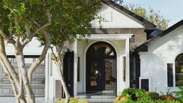 Una casa residencial con entrada principal, garaje y jardín bien cuidado.