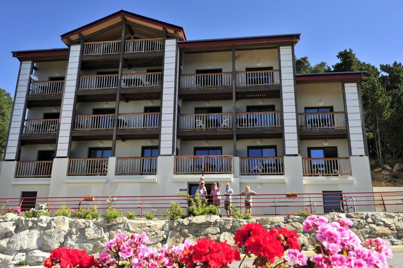 Ein mehrstöckiges Hotel mit Balkonen, einer Stein-Fassade und blauem Himmel.