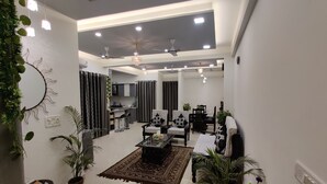 A modern living room with a coffee table, sofas, and a dining area. - Anand's Aashiyana Homestay (Agra)