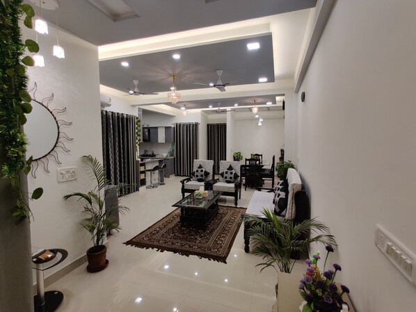 A modern living room with a coffee table, sofas, and a dining area.