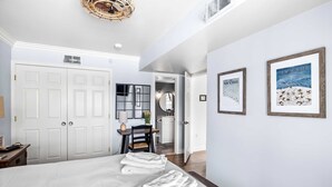 A hotel room with a large bed, a desk with a chair, a mirror, and two framed pictures on the wall. - Apres Chalet: Winterplace Ski-in/Out pool+hot tubs (Ludlow)