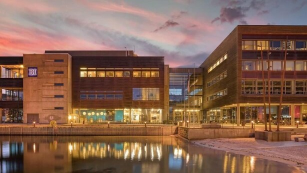 A modern building with a reflective water body in front, featuring a mix of glass and brick facades. - Cozy Studio in Bergen Center (Bergen)