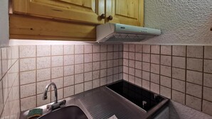 A kitchen with wooden cabinets, a stainless steel sink, and a Bosch range hood. - 70m from ski slopes, 3rd floor, view ski slopes, balcony, tv, 27m², Méribel-Mottaret (Méribel - Les Allues)