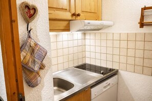 A kitchen with a Bosch dishwasher, a stainless steel sink, and a heart-shaped decoration on the wall.
