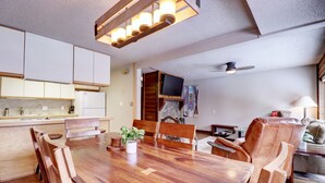 A modern kitchen with white cabinets, a wooden dining table, and a ceiling fan. - An202 Anaconda 2br 2ba 2 Bedroom Condo (Copper Mountain)