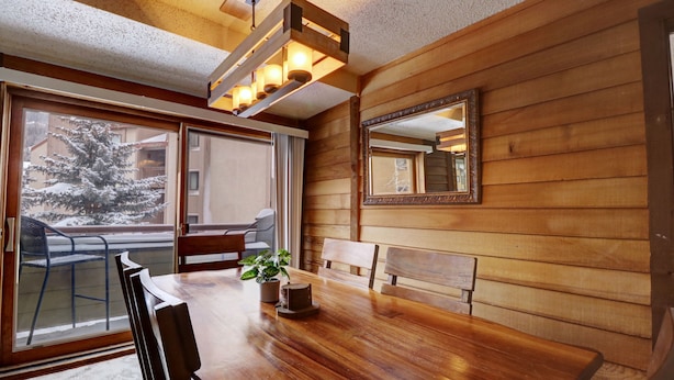 A wooden interior with a dining table, chairs, a potted plant, and a large mirror on the wall. - An202 Anaconda 2br 2ba 2 Bedroom Condo (Copper Mountain)