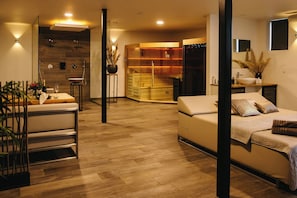 A modern interior with a sofa, dining table, and a built-in kitchen area.