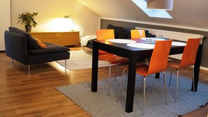 A dining area with a table, chairs, and a ceiling light. - City-Center Apartment with Loggia and Parking (Würzburg)