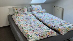 A small, single-bed room with a sloped ceiling and a skylight. - City-Center Apartment with Loggia and Parking (Würzburg)