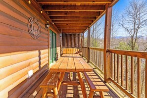 A wooden cabin with a covered porch, a bench, and a view of the surrounding landscape. - Spacious Cabin for 8 w/Hot Tub & Mountain Views! (Gatlinburg)