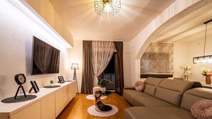 A modern living room with a sofa, a TV mounted on the wall, a lamp, and a plant. - Villa Mendula Zadar Villas (Novigrad)
