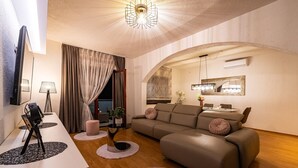 A modern living room with a sofa, a dining table, and a TV. - Villa Mendula Zadar Villas (Novigrad)
