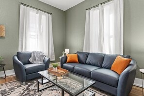 A living room with two sofas, a coffee table, and a patterned rug.