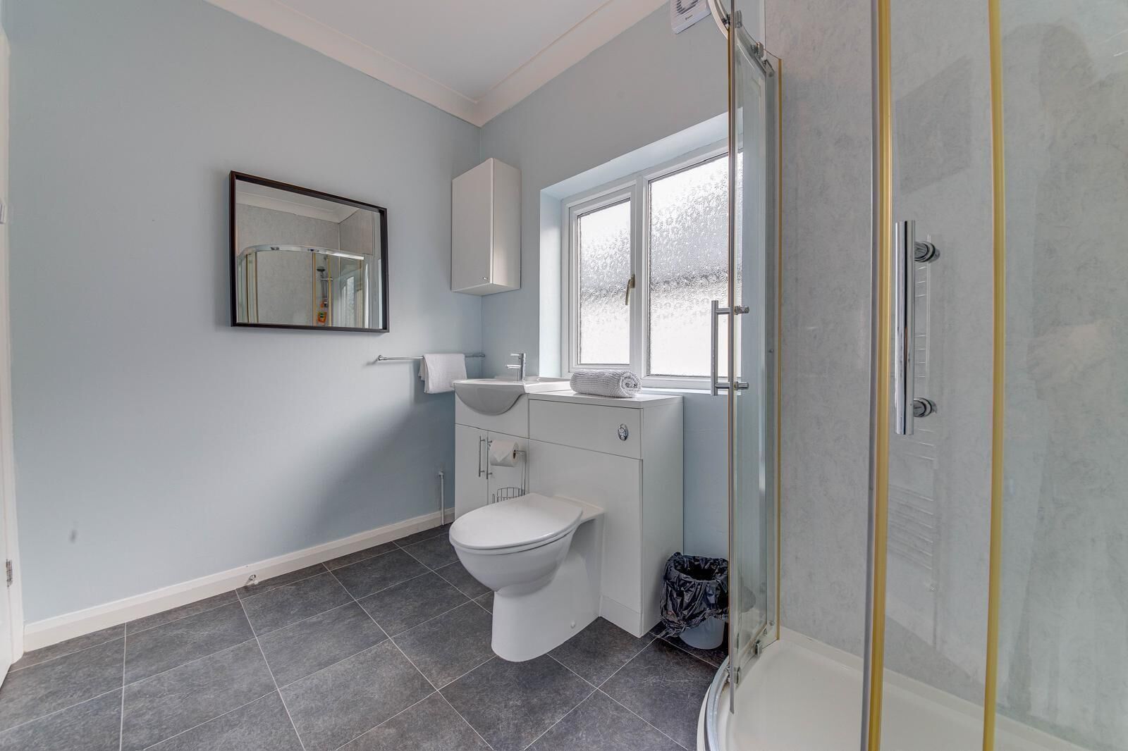 Ein modernes Badezimmer mit Toilette, Waschbecken und Dusche.