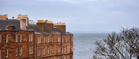 A multi-story building with a view of the sea.