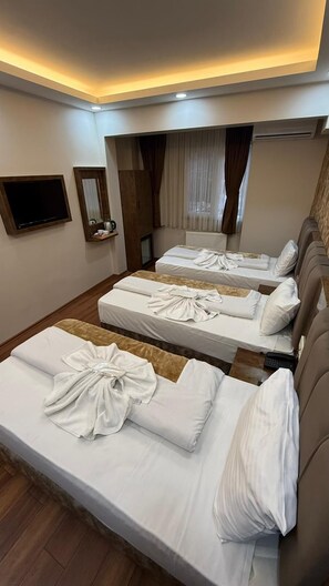 A hotel room with three beds, a flat-screen TV, a mirror, and a window with curtains. - FORTYNINE HOTEL (Istanbul)