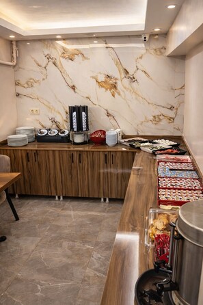 A buffet area with marble walls, a wooden counter, and various food items. - FORTYNINE HOTEL (Istanbul)