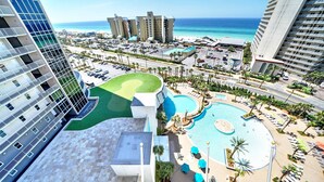 Un resort con piscina, palmeras y vistas al océano.
