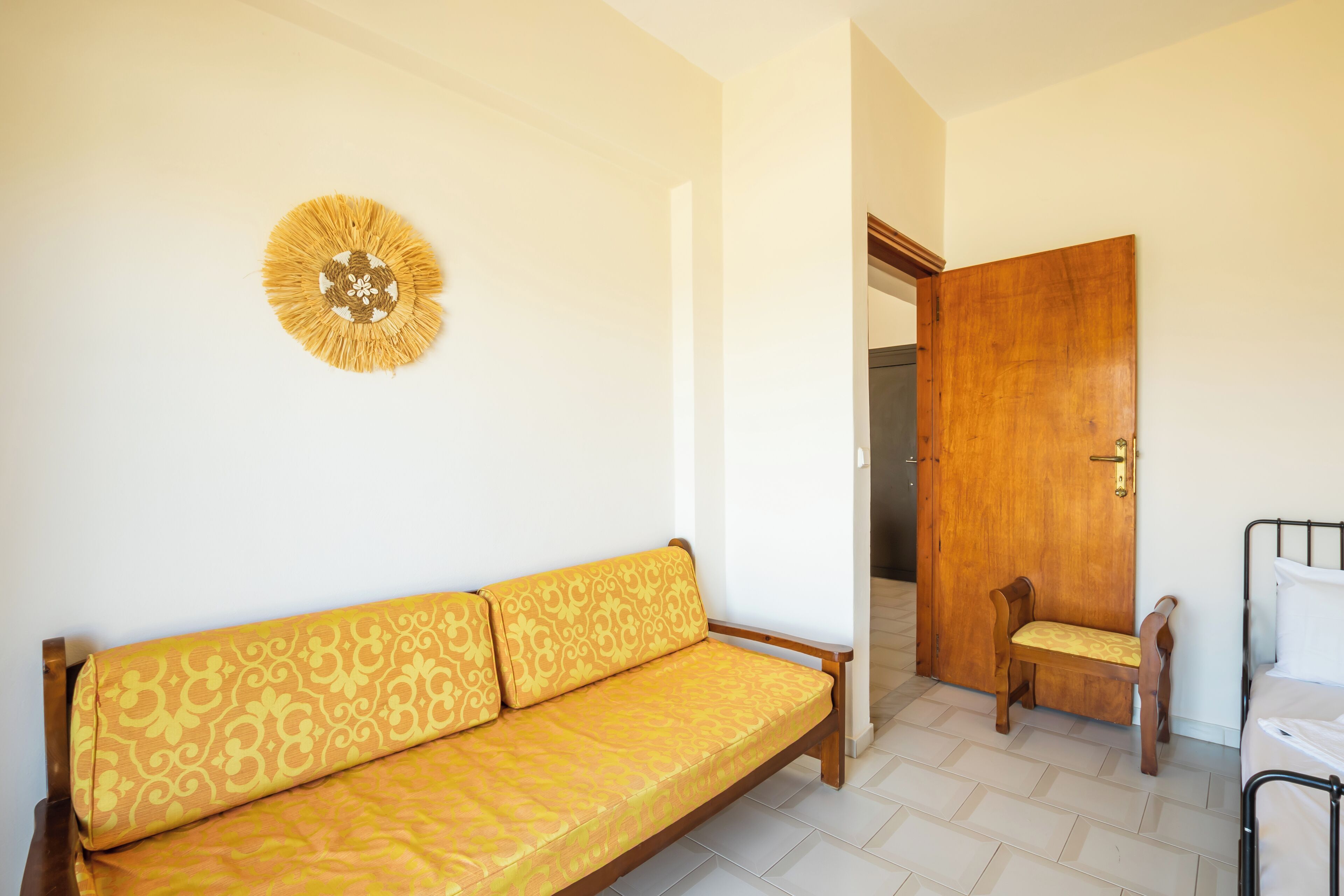 Una habitación con sofá, puerta de madera y cama.