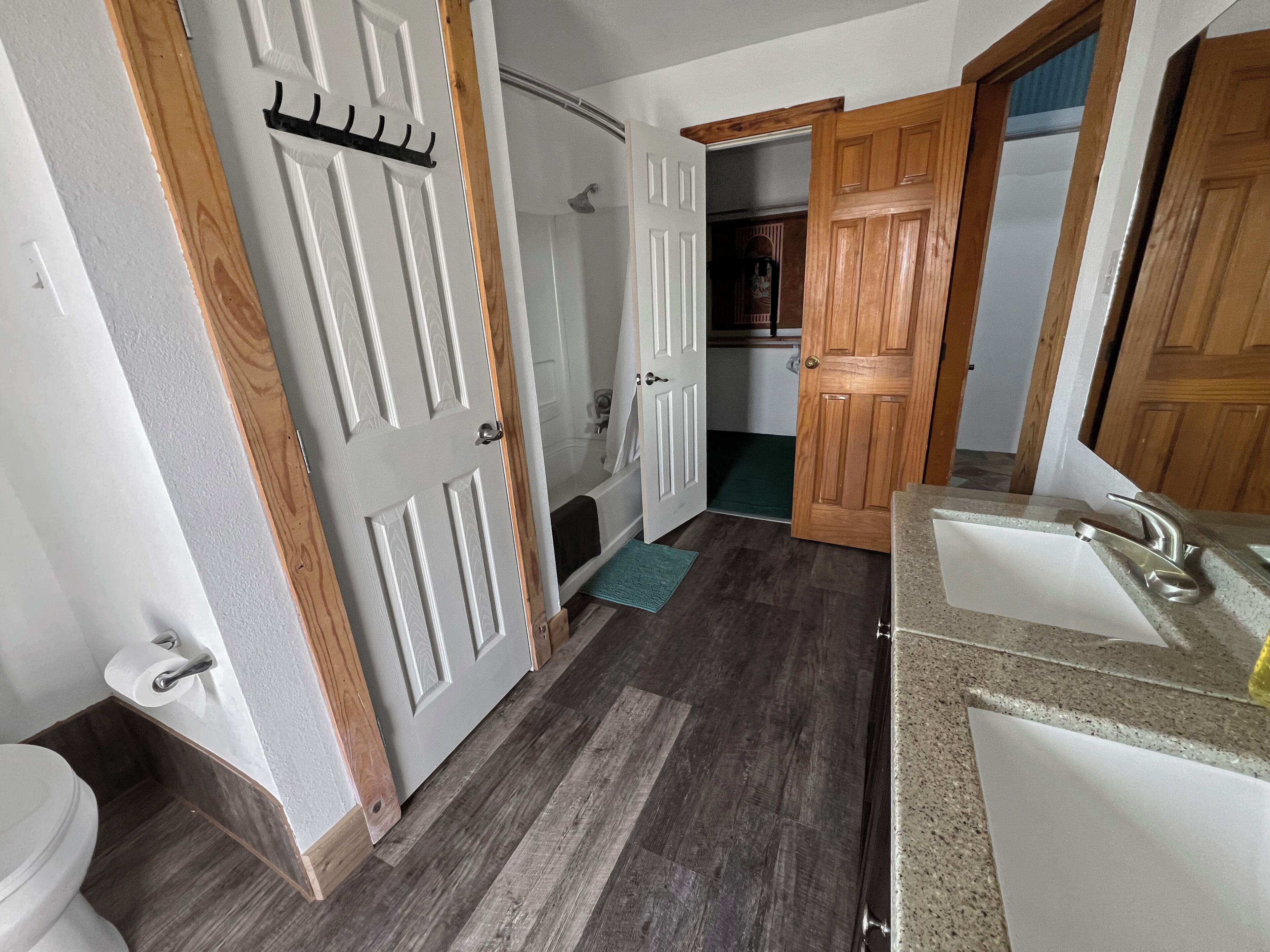 Baño con inodoro, lavamanos y zona de ducha.