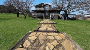 Una casa de dos pisos con un sendero de piedra que lleva a la puerta principal.