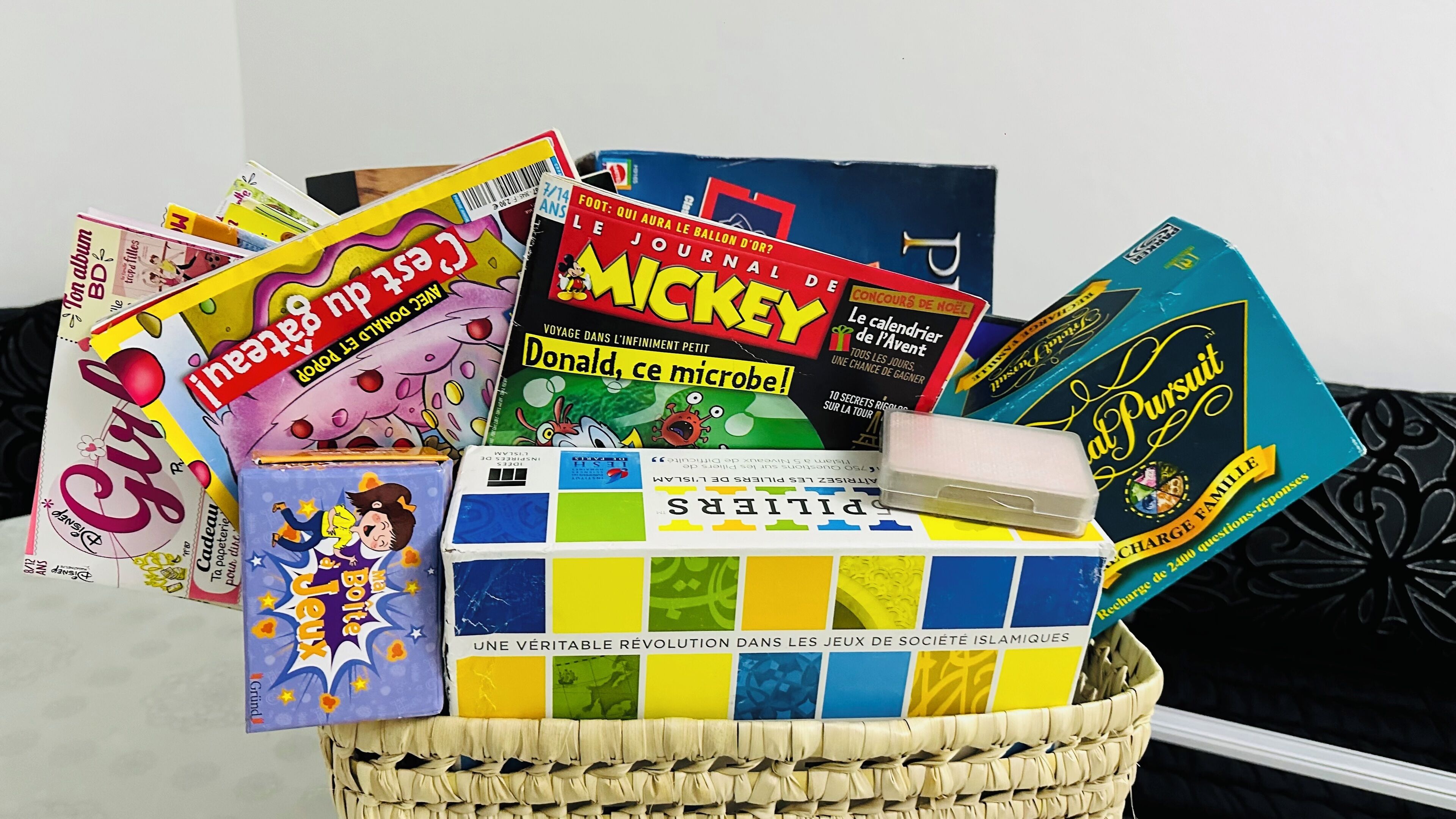 Un panier rempli de divers livres et magazines, notamment des titres comme « Mickey » et « Donald, ce microbe ! ».