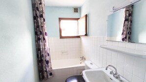 Un baño con inodoro, lavamanos y bañera.