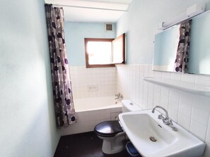 A bathroom with a toilet, sink, and bathtub. - 1st floor, balcony, parking, ski locker, 32m², Le Grand Bornand (Le Grand-Bornand)