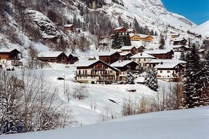 A snow-covered mountain village with wooden houses and a ski slope. - 1st floor, balcony, parking, ski locker, 32m², Le Grand Bornand (Le Grand-Bornand)
