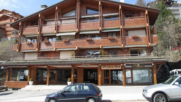 Un edificio de madera de varios pisos con balcones, una cafetería y tiendas de recuerdos.