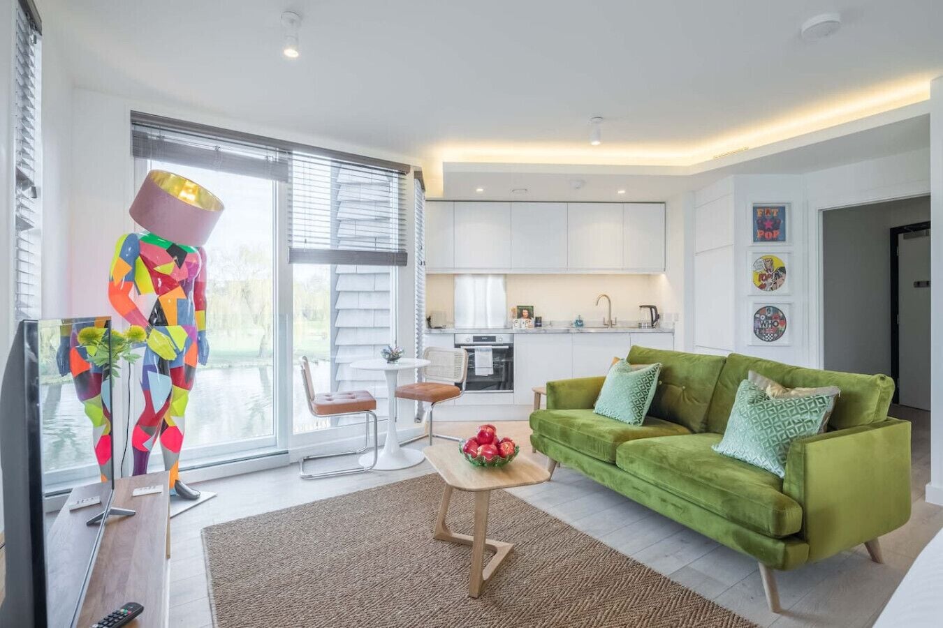 A modern living room with a green sofa, a coffee table, and a colorful abstract sculpture.