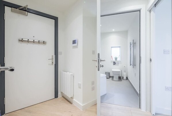 Une salle de bain moderne équipée de toilettes, d’un lavabo et d’un porte-serviettes.