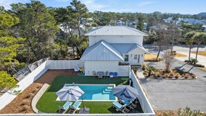 A residential property with a swimming pool, outdoor seating, and a fenced yard. - Blue Mountain Beach Retreat | Pet-Friendly | Private Pool | 5 Bikes (Santa Rosa Beach)