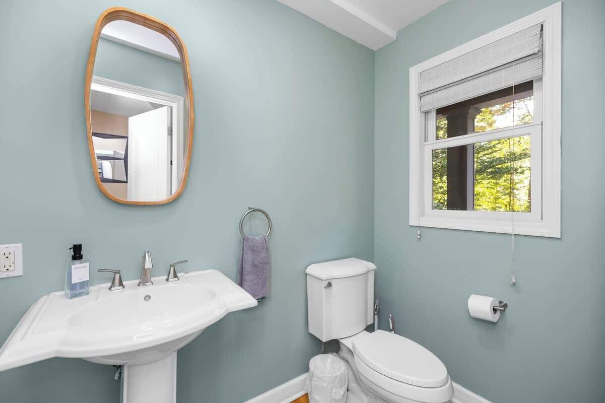 Ein Badezimmer mit Waschbecken, Toilette und einem Fenster mit Blick.
