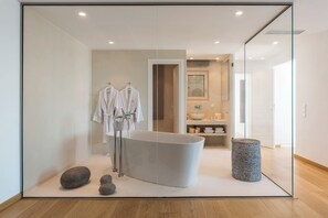 Bathroom features a bathtub, glass shower enclosure, and minimalist design.
