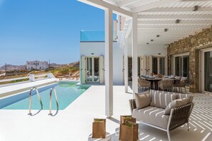 Relax by the modern pool surrounded by a spacious deck and comfortable seating.