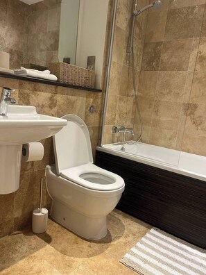 Appartement | Badkamer | Een aparte badkuip en douche, een diep bad, een haardroger, handdoeken