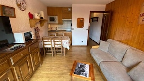 A compact living space with a kitchenette, dining area, and a sofa. - Ground floor, view village, balcony, tv, 22m², Le Grand Bornand (Le Grand-Bornand)